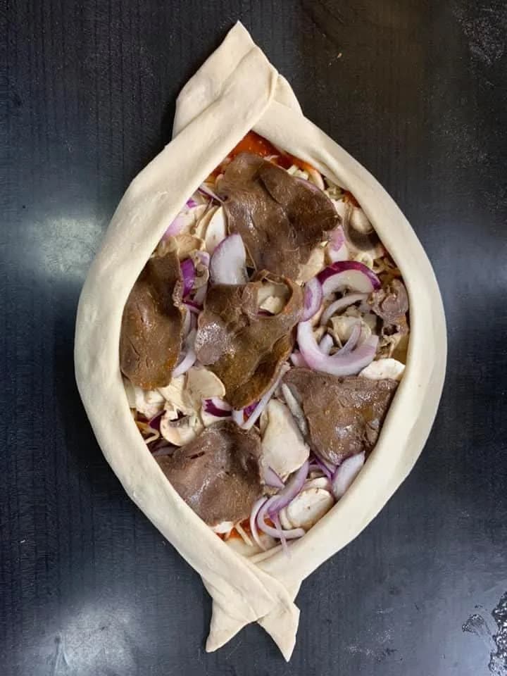 Öppen inbakad pizza med oxfilé, svamp och rödlök, redo för ugnen — Kärna Pizzeria